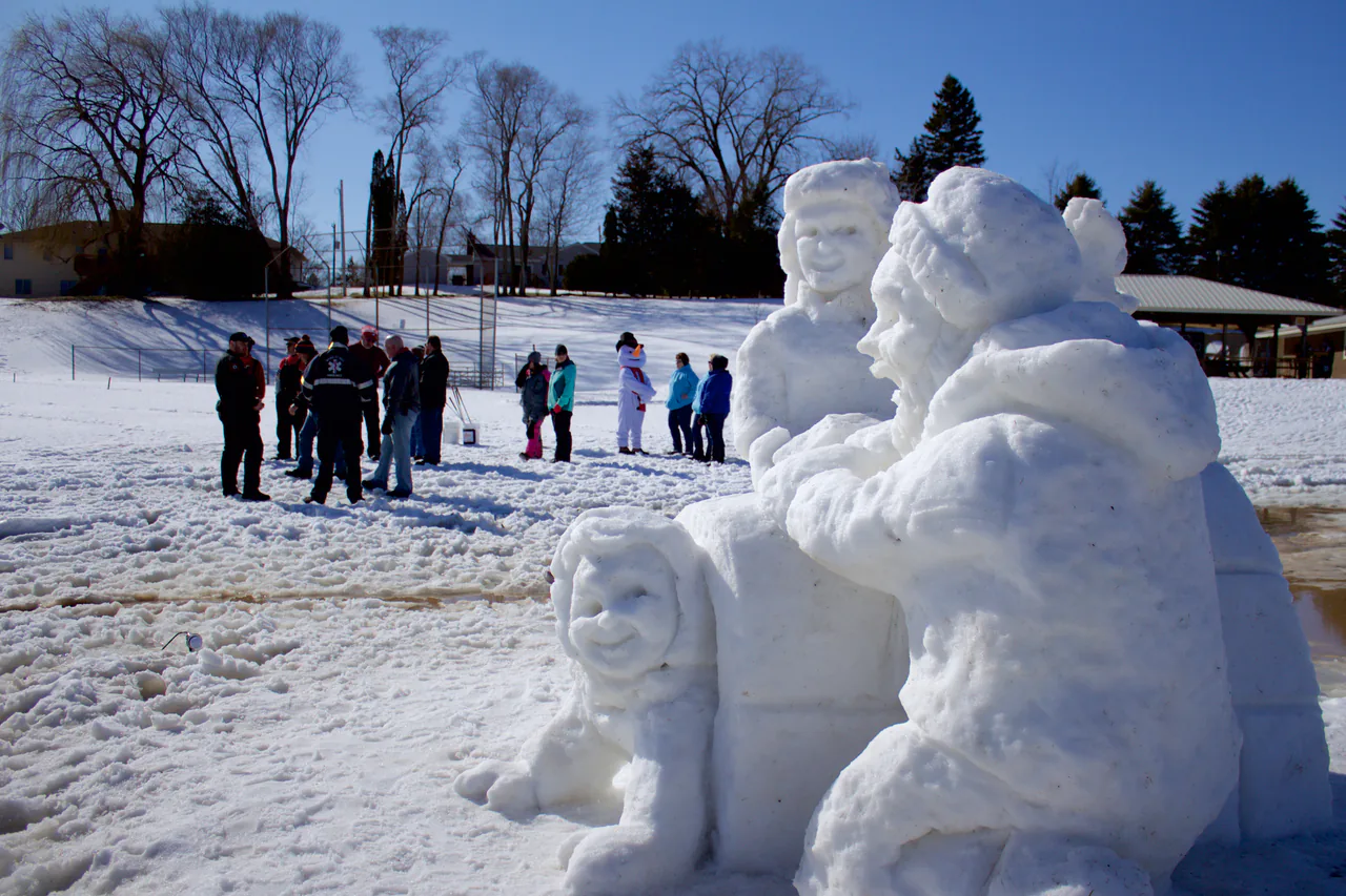 Visitors beside large snow sculptures at Winterfest in Mishicot Wisconsin