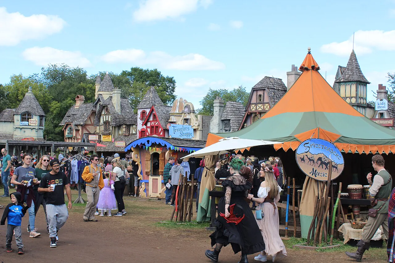 Visitors walking among food and craft booths at the Minnesota Renaissance Festival