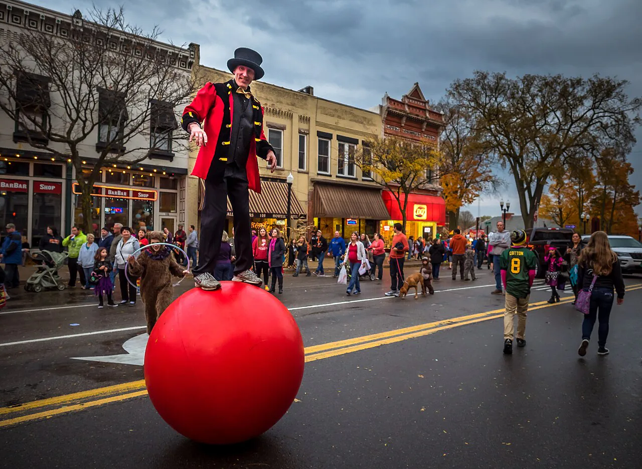 Street performer balancing on a large red ball at the Legend of Sleepy Howell festival
