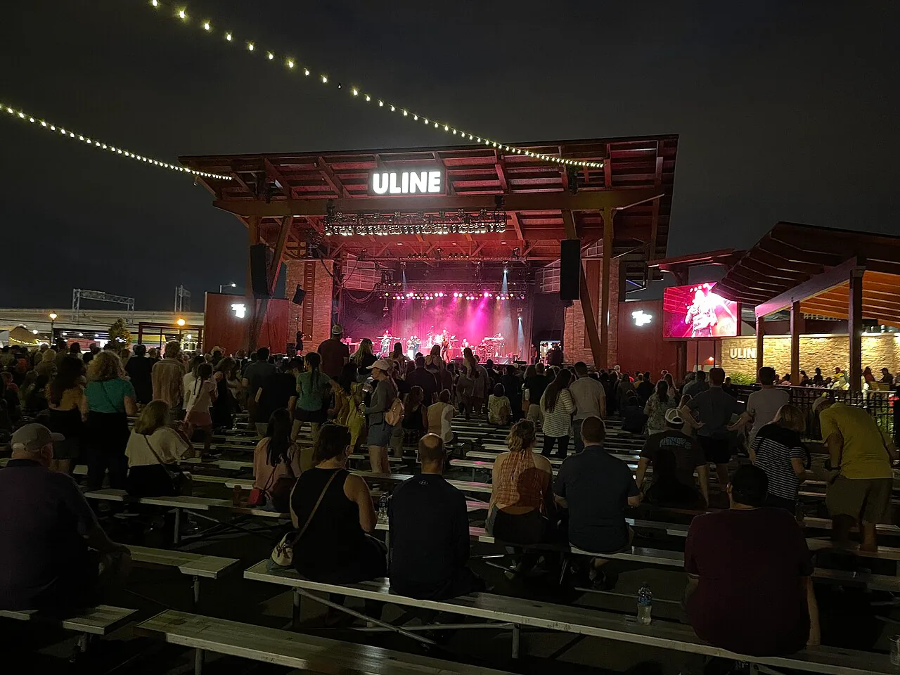 Nighttime crowd watching a concert at the Uline Warehouse stage during Summerfest